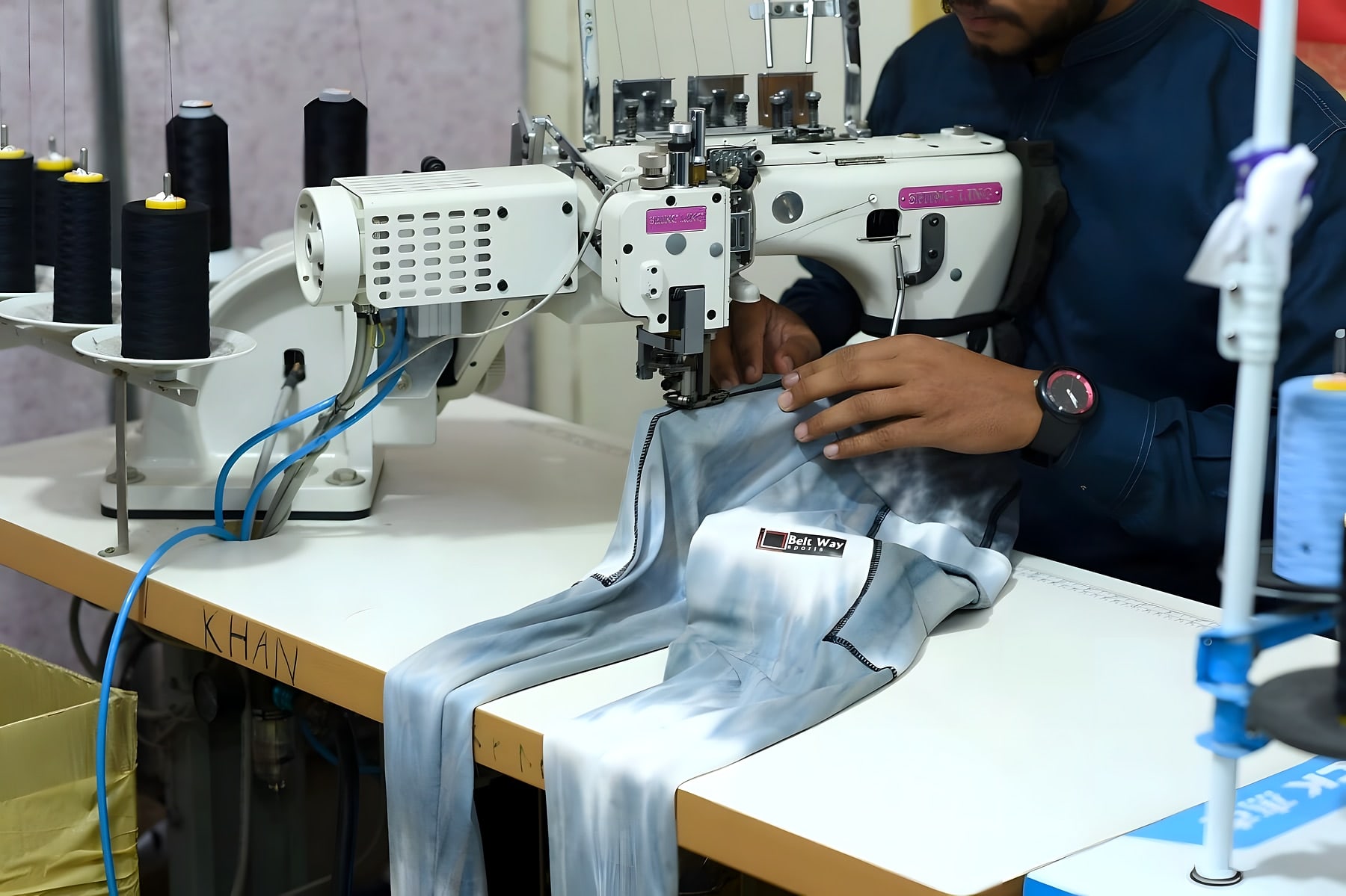 Operator stitching a printed legging at an industrial overlock machine